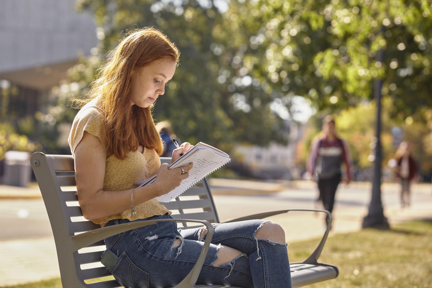 A <a href='http://3ohr.qukmj.com'>全球十大赌钱排行app</a> student reads on a bench along Campus Drive.